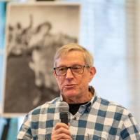 An alumni speaking to the audience.